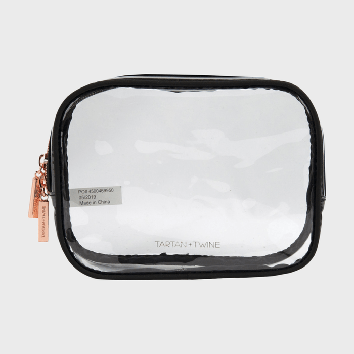 A clear cosmetic bag displays branding text 