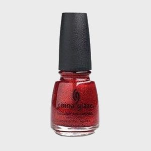 Red nail polish bottle stands upright; features a black cap and clear glass base, set against a plain gray background.
