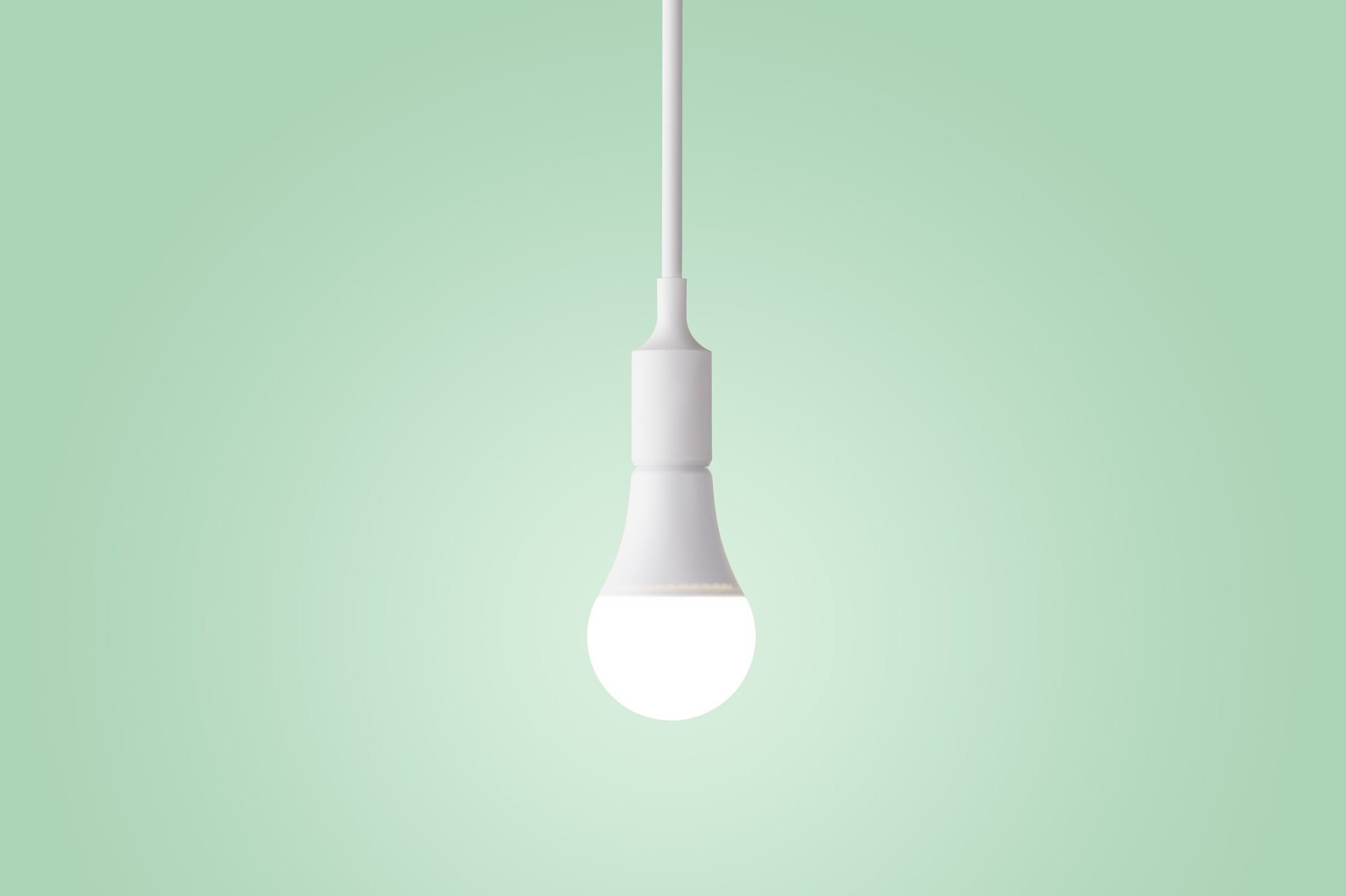 Illuminated LED Light Bulb Glowing on Green