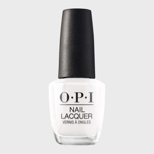 A bottle of white nail lacquer sits against a solid gray background, labeled 