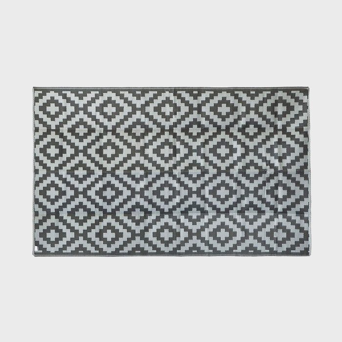 Rectangular rug displaying black and white diamond pattern against neutral background.
