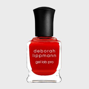 Nail polish bottle stands upright, displaying bright red color, labeled 