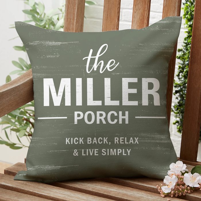 A green cushion rests on a wooden bench; it reads, 