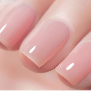Fingernails display a soft pink glossy manicure, shown close-up, highlighting their smooth and polished surface.