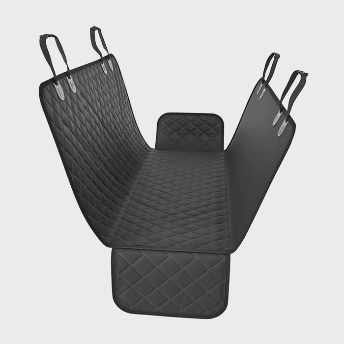Quilted car seat cover hangs by straps, forming a protective hammock over the backseat, in a neutral studio setting.