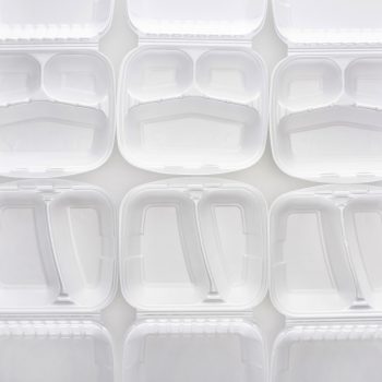 White, open clamshell food containers are arranged neatly in a grid pattern against a plain background.