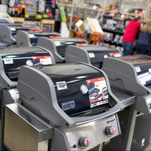 Grills displayed in a store aisle, sitting idle, with price tags reading 