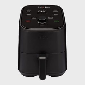 Air fryer displays digital timer and buttons for cooking modes on a smooth, black surface in a neutral background.