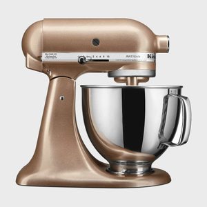 Mixer stands inactive in a kitchen setting, featuring a shiny metal bowl and various speed settings labeled on its side panel.