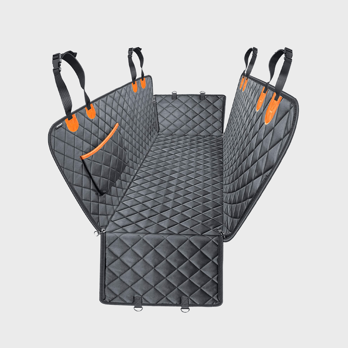 Quilted pet seat cover with straps extended forms a protective barrier; features a pocket, designed for car back seat protection.