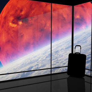 Suitcase stands near glass windows, overlooking a vivid planet and cloud-filled horizon, suggesting a futuristic travel setting.
