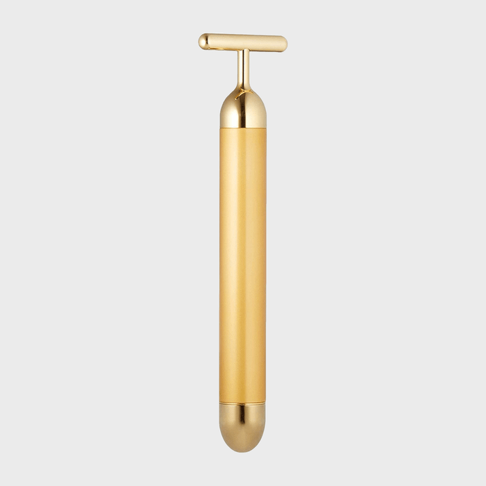 A sleek gold bottle stopper with a T-shaped handle, resting vertically against a plain white background.