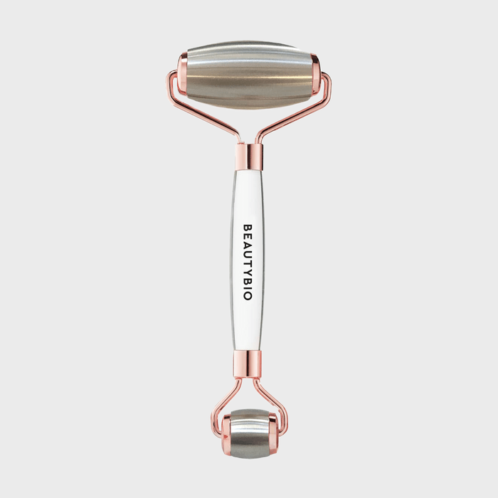 Facial roller with metal rollers, stationary, against a plain white background. Branding 
