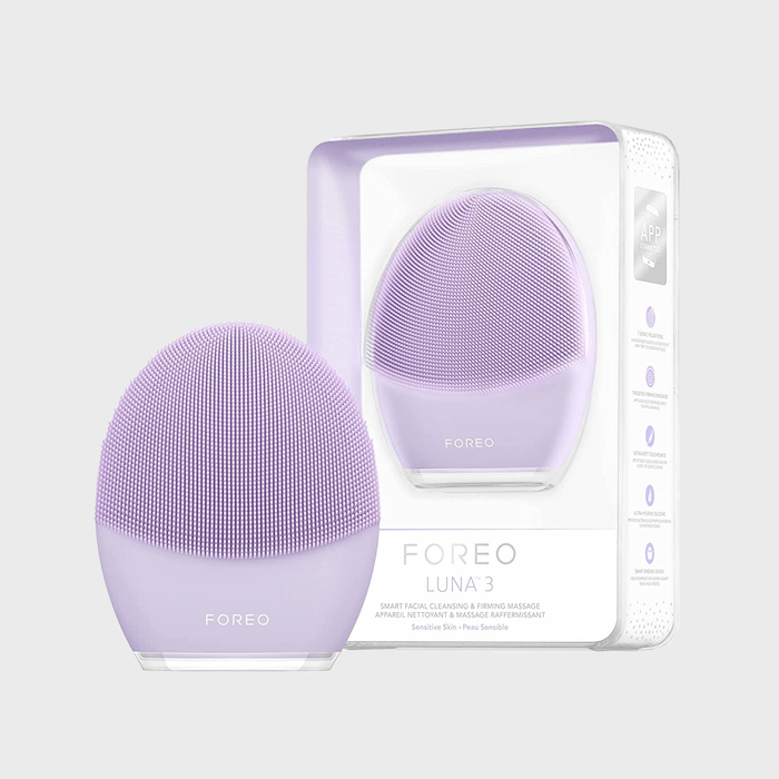 Lavender facial cleansing device stands beside its packaging, showcasing 