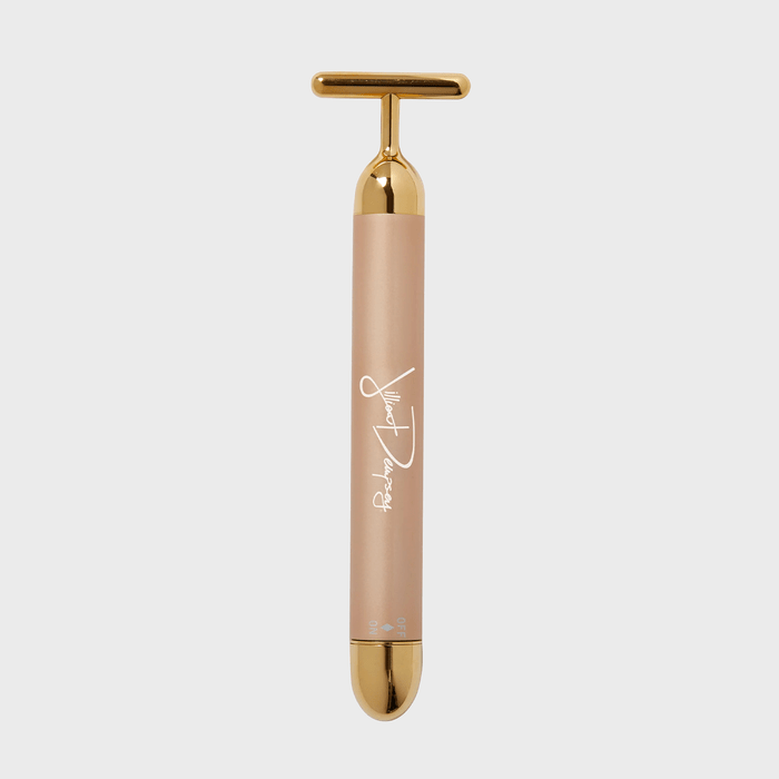 Golden facial roller standing vertically on a plain white background with cursive text reading 