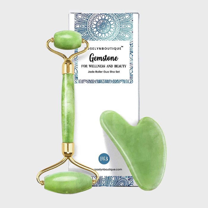 Jade roller and gua sha tools displayed; set against decorative packaging with blue patterns, text reads: 