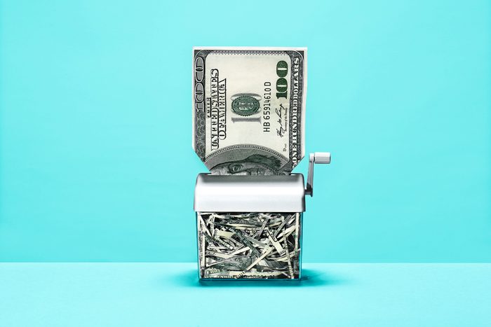 100 dollar bill going through manual shredder