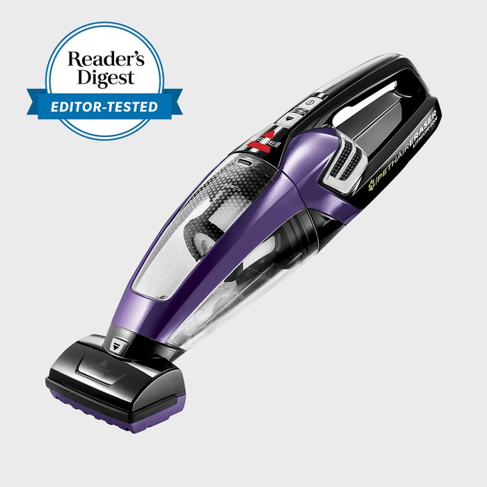 Handheld vacuum rests on a plain background. Blue 