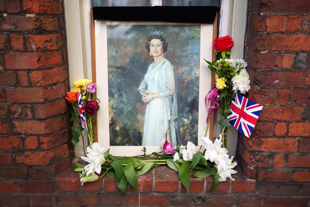A portrait of Queen Elizabeth II and tributes sit on the window sill of home near Windsor Castle on September 16, 2022 in Windsor, United Kingdom
