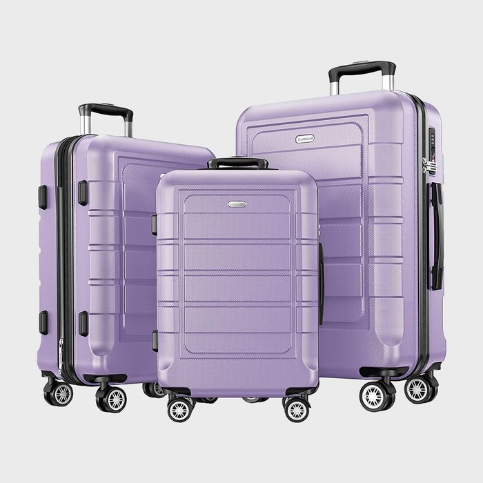 Three purple suitcases stand upright, featuring four spinning wheels and extended handles, on a plain white background.