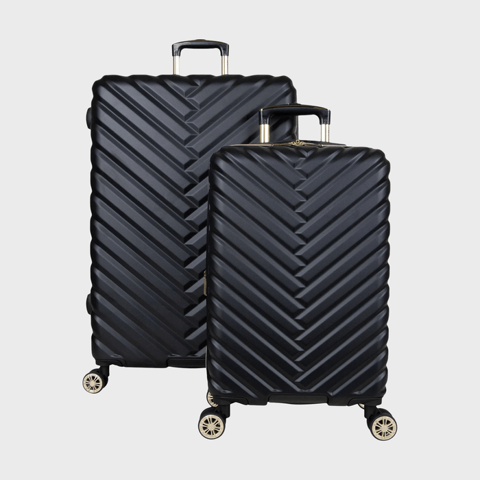 Two black suitcases stand on wheels, displaying a zigzag pattern, with a plain light background.
