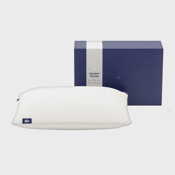 A white pillow rests in front of a navy box labeled 