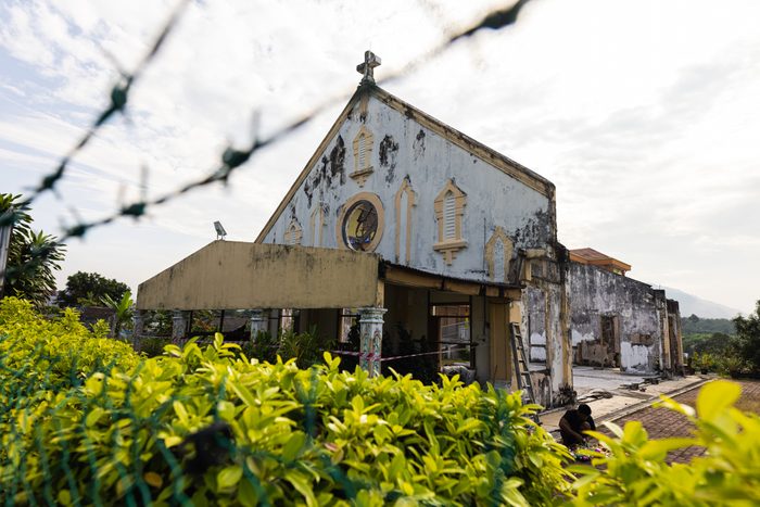 the ruin of a church behind barbed wire