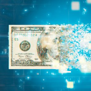 A hundred-dollar bill pixelates and dissolves into digital bits, set against a vivid blue, technological backdrop.