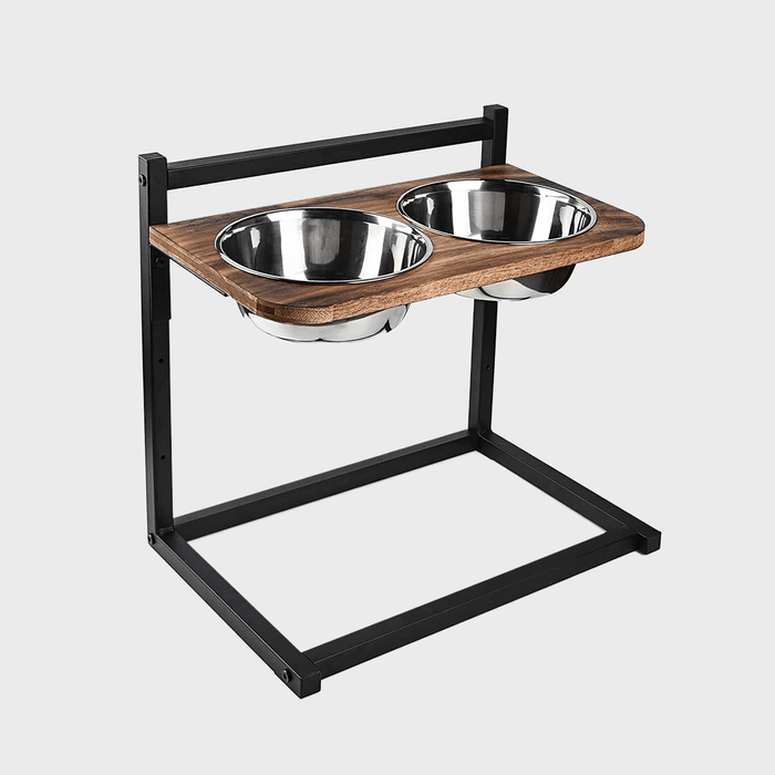 Two stainless steel bowls are fixed in a wooden frame elevated by a black metal stand on a plain background.