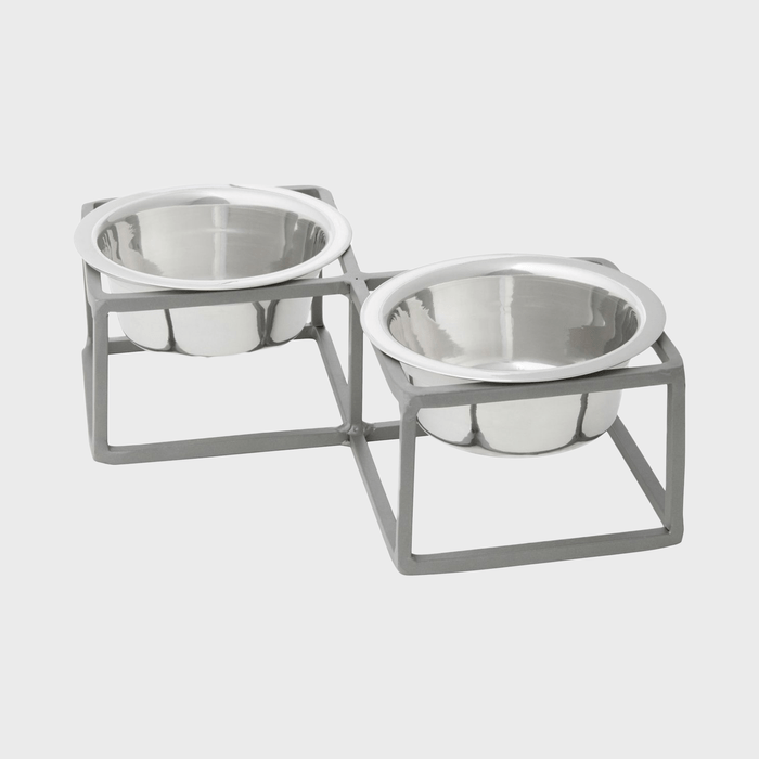 Two stainless steel pet bowls sit in a gray metal stand, designed for feeding, placed against a plain white background.
