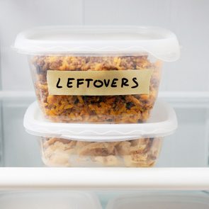 Containers stack in a fridge. Top container labeled 