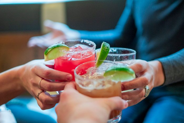 Friends toasting with margaritas and tropical drinks