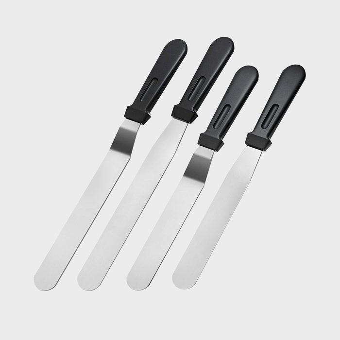 Four metal spatulas with black handles are arranged side by side against a plain white background.