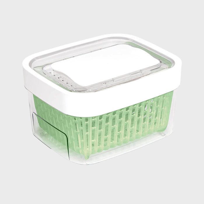 Plastic container holds a green basket inside, covered with a clear, white-rimmed lid; set against a plain, light background.