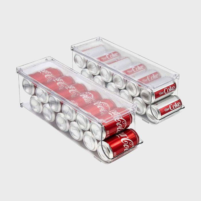 Transparent containers hold rows of red Diet Coke cans, neatly stacked in an orderly manner against a plain backdrop.