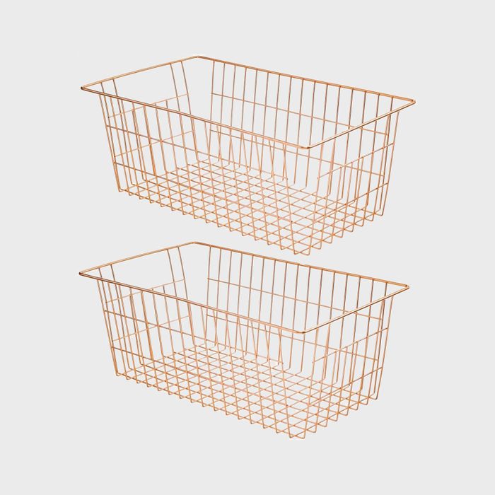 Two copper wire baskets are stacked vertically, floating against a plain white background.