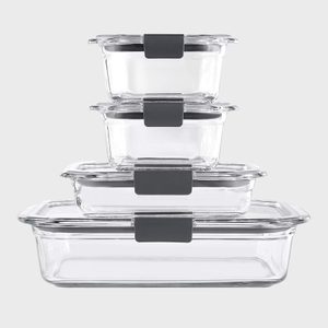 Stacked glass food containers with gray lids, set on top of each other against a plain gray background.