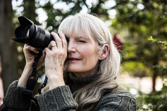 Woman taking nature photographs outdoors