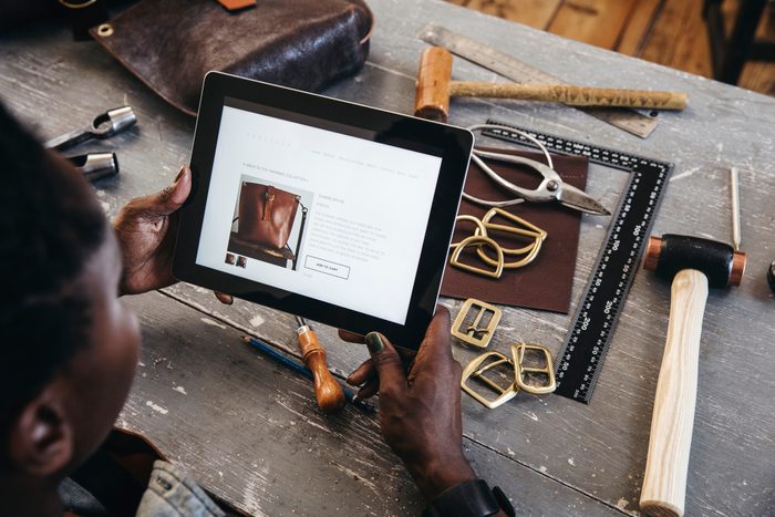 Small Business Owner looks at her website on a digital tablet