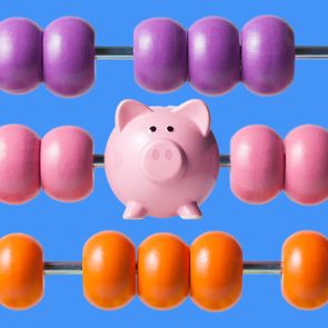 Pink piggy bank sits among colorful abacus beads on a blue background.
