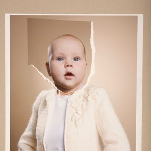 A child's portrait appears carefully torn, with the head section tilted, set against a plain beige background.