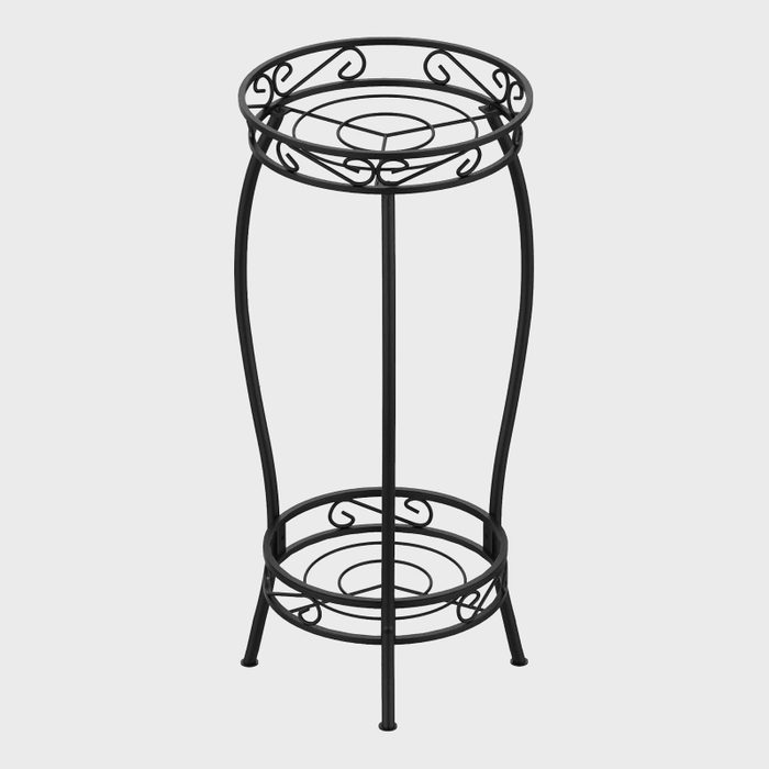Black metal plant stand features intricate scrollwork, standing upright against a plain gray background.