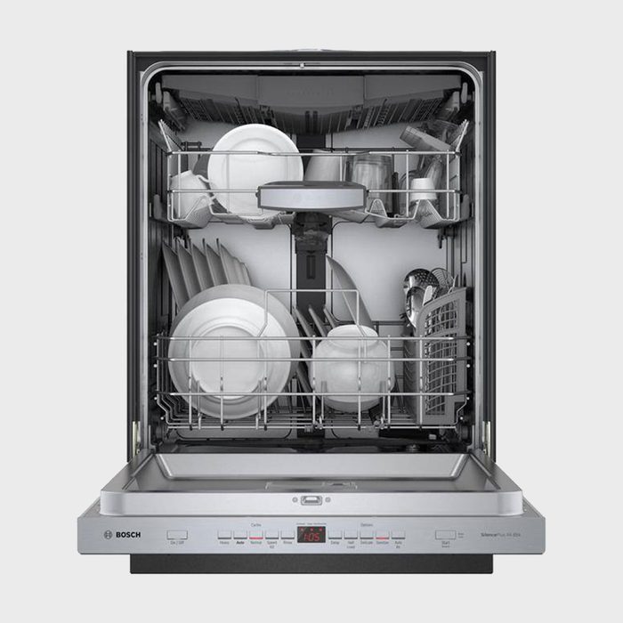 Dishwasher holds assorted dishes and glasses in racks, situated in an open kitchen appliance. Bosch branding and control panel with digital display visible.
