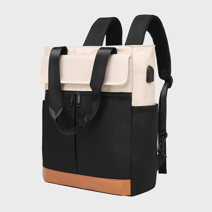 Backpack stands upright; features black, beige, and brown colors with a zippered pocket and USB port; displayed against a plain gray background.