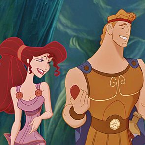 Two animated characters, smiling and interacting, in a lush forest background. One wears a purple dress; the other, a warrior outfit holding a disk.
