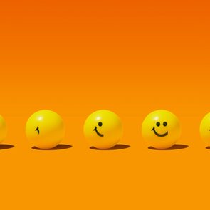 Five yellow balls progress from neutral to smiling faces, aligned on an orange background.