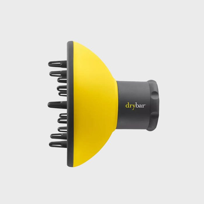 Hairdryer diffuser, with pronged attachments facing left, sits on a plain gray background. The word 