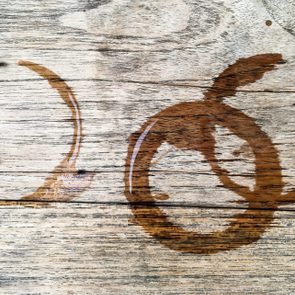 Wooden surface displays two overlapping circular water stains, suggesting previous placement of a wet glass in a rustic setting.