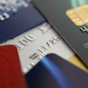 Credit cards overlap slightly, revealing embossed numbers and expiration dates in various colors, emphasizing financial theme and transaction elements.