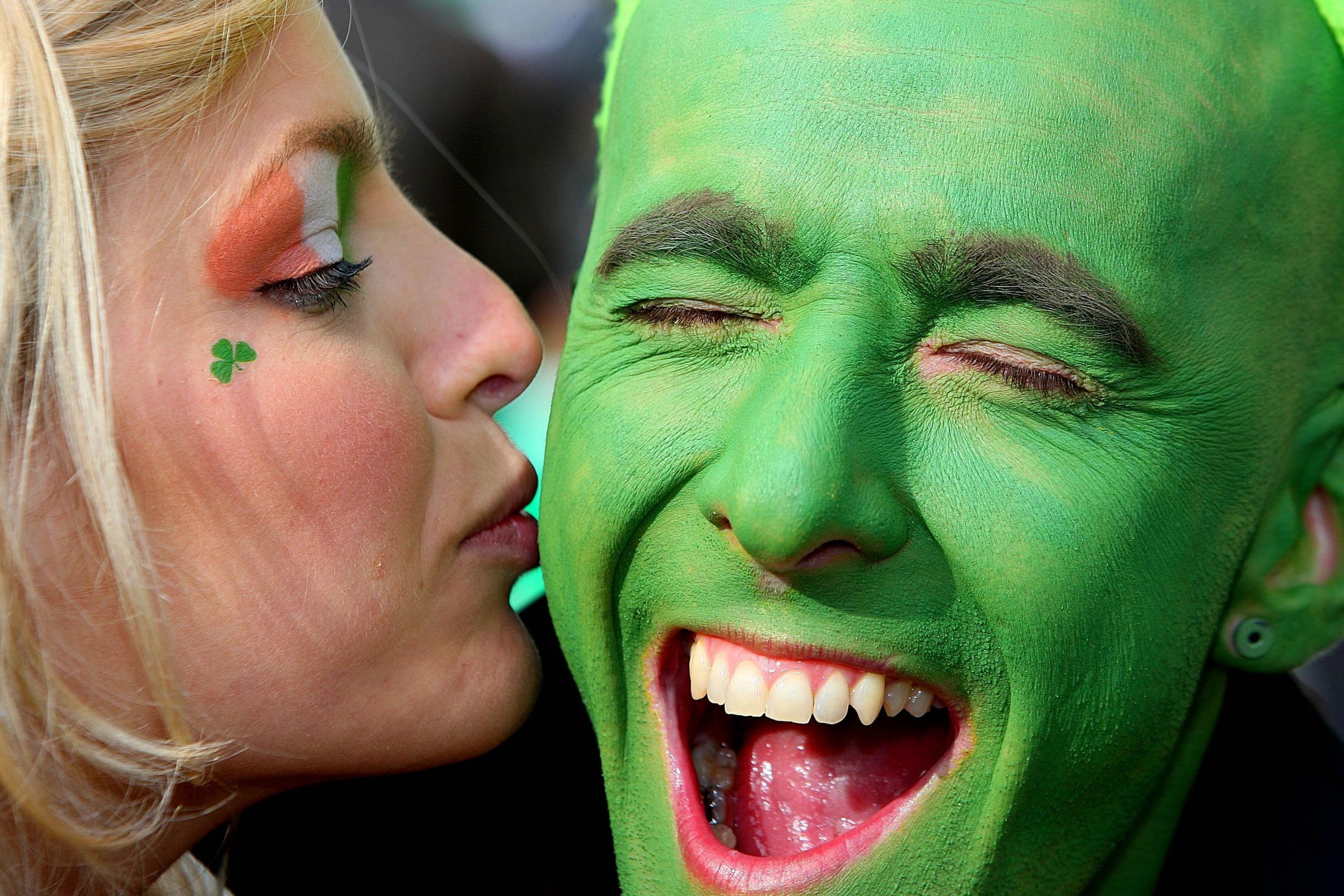 A performer gets a kiss from a young woman during the annual St Patricks Day Parade